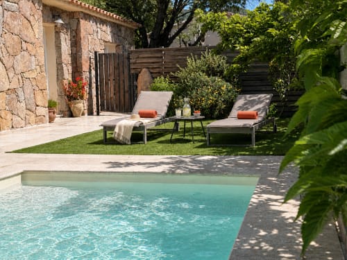Piscine et transats à In Casa Conciergerie, propriété de luxe à Figari en France avec villa en pierre et jardin verdoyant