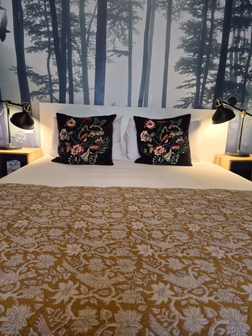 Chambre d'hôtel moderne à l'Hôtel Du Cygne Tours avec coussins fleuris, papier peint forêt et éclairage chaleureux