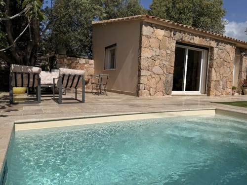 Ogliastru cottage pool view at In Casa Conciergerie, Figari - stone building with turquoise pool and lounge seating