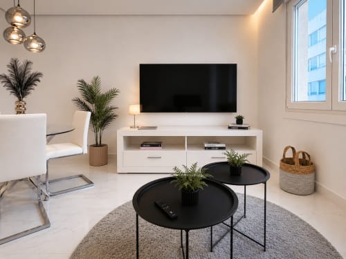 Moderna sala de estar en Holibai apartamento en Baiona con TV, muebles minimalistas y vistas a la ciudad