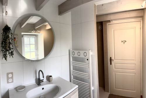 Chambre la Chouanne bathroom at Logis De La Bénétière, Treize-Vents with round mirror, sink, and towel rack