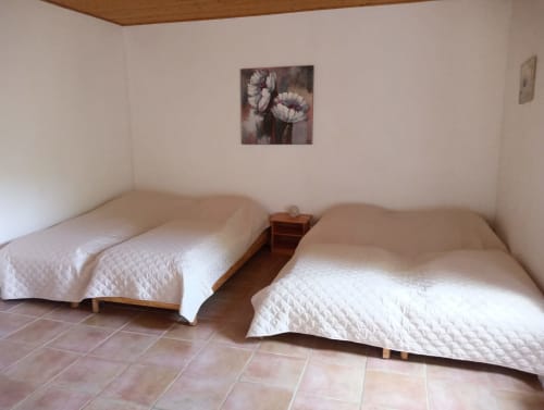 Chambre twin du gîte La Faerie à Grand'landes avec édredons blancs et vue sur le jardin