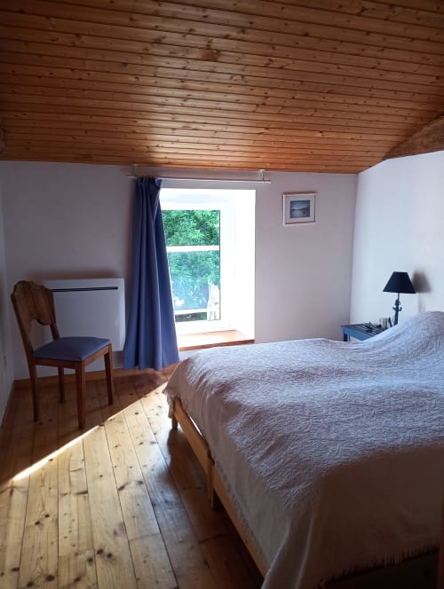 Chambre lumineuse à la gîte La Faerie à Grand'landes avec plafond en bois, vue sur le jardin et design PMR accessible