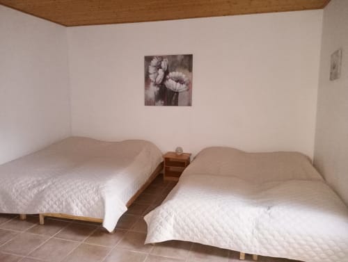 Chambre twin à la gîte La Faerie avec lits matelassés blancs, table de nuit en bois et décor floral à Grand'landes