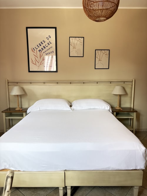 Camera luminosa presso Sicily In Home a Catania con letto bianco, testiera verde salvia, comodini coordinati con lampade, e