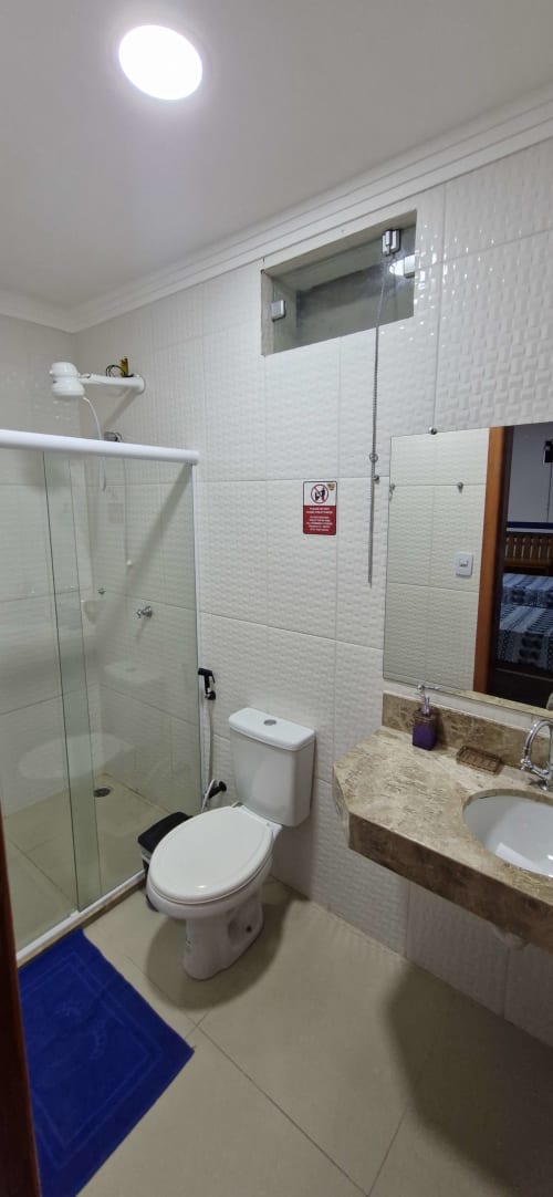 Modern bathroom in Suíte Queen Tripla at Praieira Pousada hostel, Itacaré, with glass shower, toilet, and marble sink