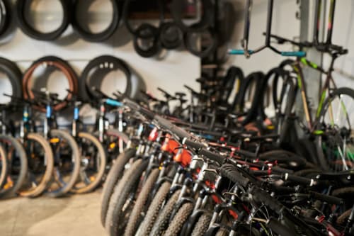 Deposito biciclette a Makasa BnB a Villapiana, Italia con bici e attrezzature ordinate su scaffali a parete