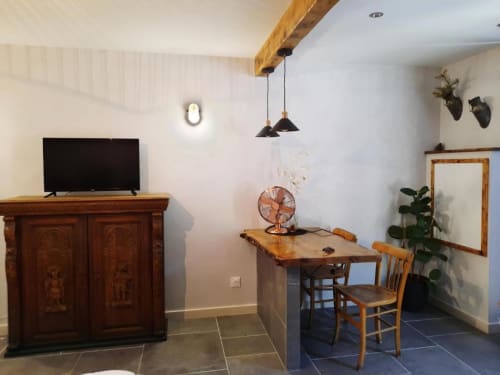 Coin salon rustique au Petit Bégou avec poutres apparentes, mobilier vintage et luminaires suspendus