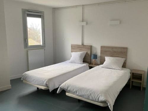 Chambre twin à l'hôtel Maison Du Haut Salat à Seix avec têtes de lit en bois et literie blanche