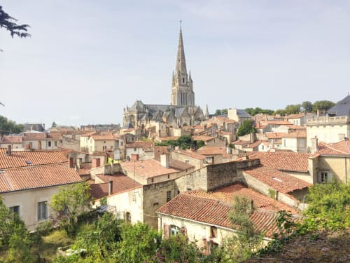 Toits d'un village médiéval français avec clocher d'église, Le Langon - Gîte L'Écrin des Roches