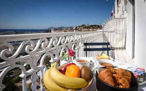 Frühstücksbuffet auf dem Balkon des Hotel Splendid Cannes mit Meerblick auf Marina und Hafen, Croissants und Früchte