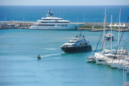 Luxusyachten und Segelboote in türkisfarbenen Gewässern im Hafen von Cannes mit Marinablick