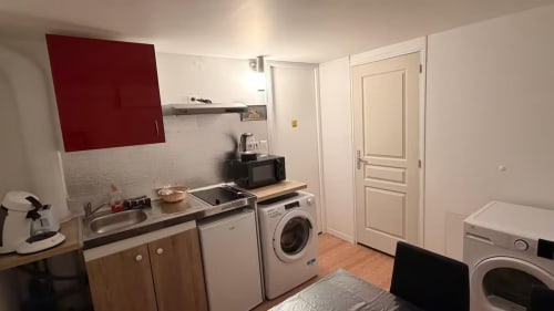 Cuisine-séjour moderne dans un appartement des Louvres avec meuble accent rouge, électroménagers et machines à laver