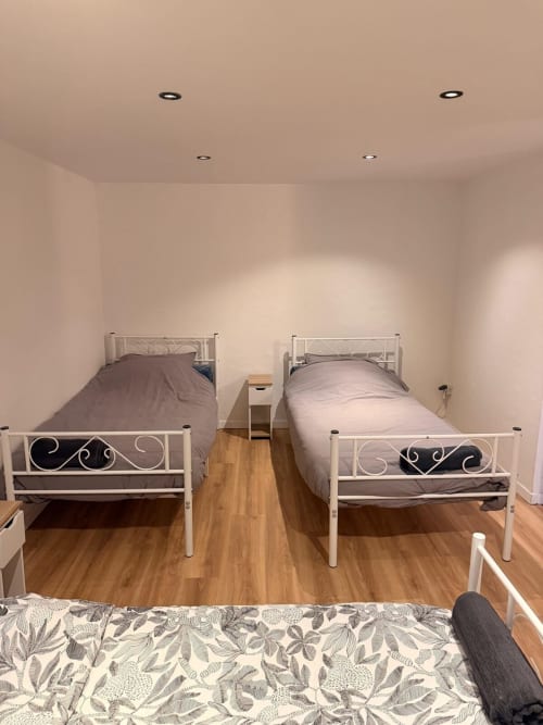 Chambre lumineuse de la location Kawichimmo à Louvres, avec deux lits simples et parquet
