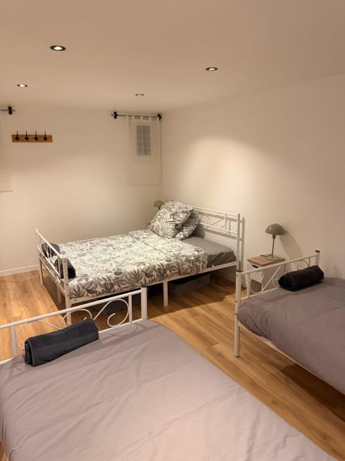 Chambre spacieuse aux Locations Kawichimmo à Louvres avec deux lits simples et parquet