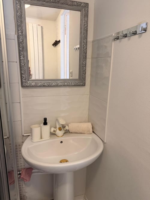 Lavabo moderne avec miroir orné dans l'appartement Kawichimmo Locations à Louvres, France