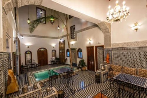Cour somptueuse du riad Le Cedre D'argent à Fès, avec carrelage zellige, fontaines et mobilier traditionnel marocain