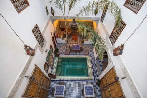 Vue aérienne de la cour du riad Le Cèdre D'argent à Fès avec bassin central, zelliges bleus et architecture traditionnelle