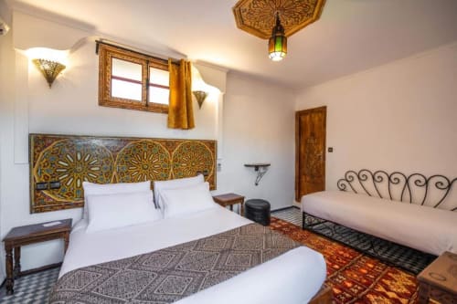 Chambre Double Confort au Le Cedre D'argent à Fès avec décor de style marocain, tête de lit ornementale, draps blancs et