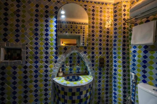Salle de bain aux mosaïques colorées marocaines avec niche voûtée à l'hôtel Le Cèdre d'Argent à Fès