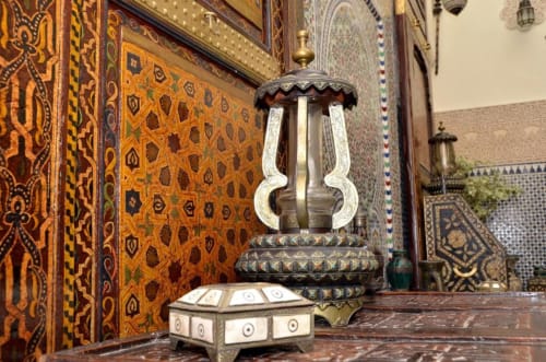 Cour ornementée du Riad Dar Tahri à Fès avec lanterne en laiton ouvragée et zelliges sophistiqués