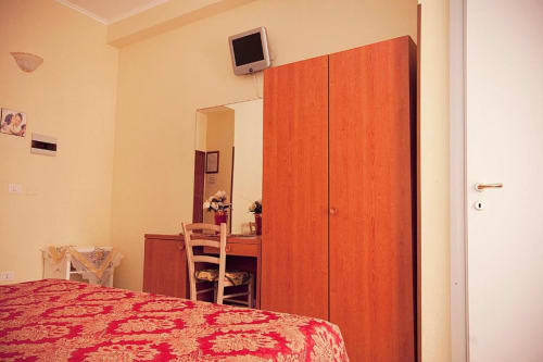 Camera da letto di Parioli House Rome B&B con armadio rosso, scrivania trucco e copriletto a motivi