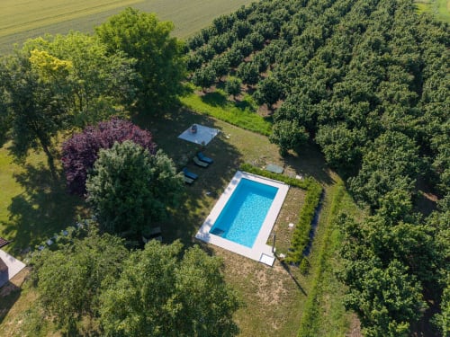 Vista aerea della piscina di Miravigne House circondata da alberi nella campagna di Castagnole delle Lanze, Italia