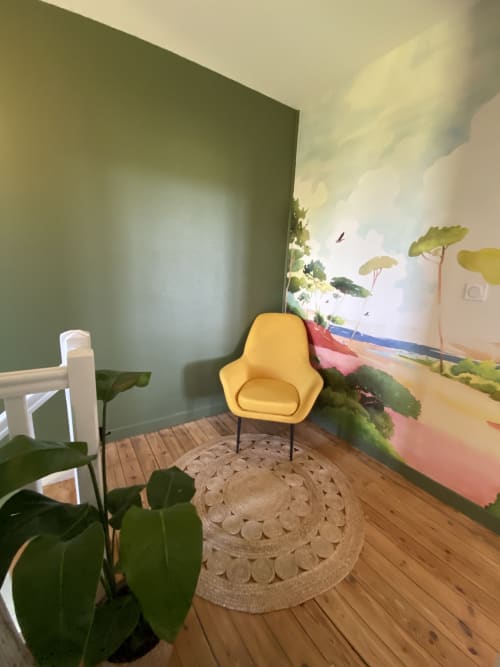 Coin lounge cosy au Domaine les Olivoux avec fauteuil jaune, plantes en pot et fresque murale à Pomport