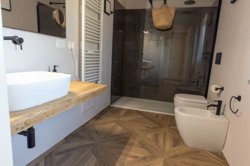 Moderno bagno di Miravigne House con lavabo bianco, piano in legno, cabina doccia scura e bidet