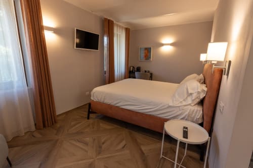 Camera moderna della Miravigne House a Castagnole delle Lanze con letto in legno, TV e arredi contemporanei