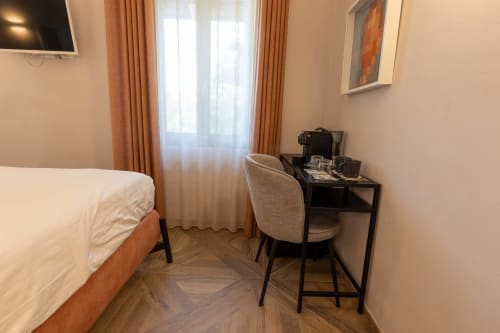 Camera moderna di Miravigne House con letto, scrivania, TV e accesso alla terrazza a Castagnole delle Lanze