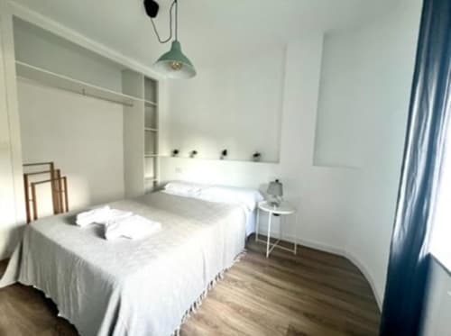 Dormitorio luminoso en Apartamento Jacaranda de ROILA360 Alicante con camas gemelas, aire acondicionado y vistas al jardín