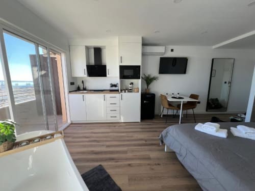 Moderno estudio en Alicante con vistas al mar, cocina, cama, comedor y balcón con vista al océano