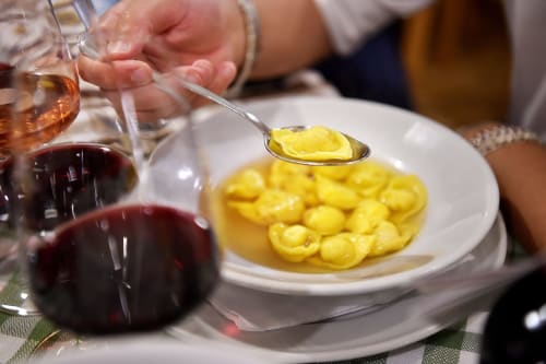 Ospite che assapora gnocchi con vino al ristorante B&B Gate 10 Fiera Bologna a Bologna, Italia