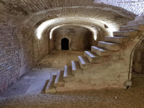 Passage souterrain voûté en briques historiques avec escalier en pierre au DOMAINE DES OISEAUX DE PASSAGE