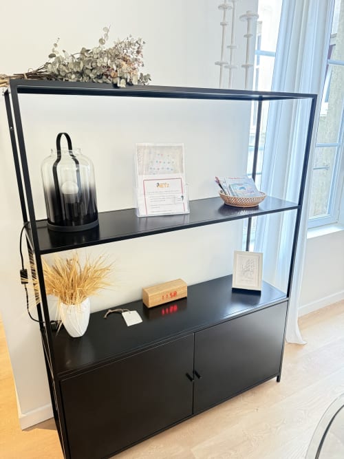 Élégante étagère noire dans l'appartement Mattbnb à Metz, présentant objets de décoration et accessoires près de la fenêtre