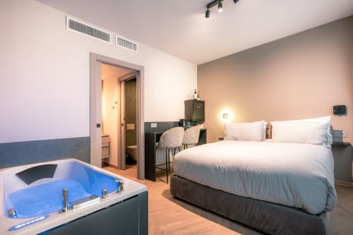 Camera d'hotel moderna a Casa Giulietta Como con letto queen, vasca spa e design contemporaneo
