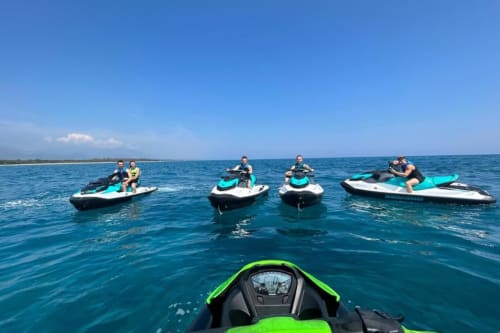 Group jet skiing in turquoise waters near Résidence Marina di Bravone, Corsica