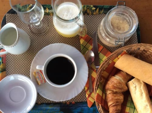 Petit-déjeuner continental à l'Art Lodge Kafé en Guadeloupe avec café, viennoiseries, pain et boissons