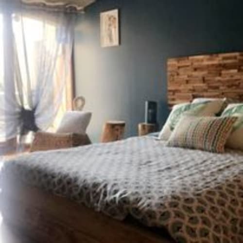 Chambre douillette aux murs bleus, tête de lit en bois et oreillers rayés à Chambre D'hôtes Magaadjukalo, Saint-Maurice-de-Lignon