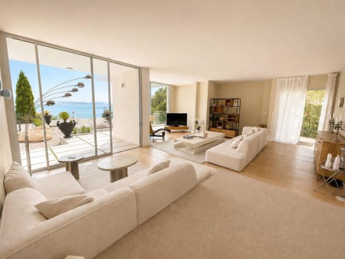 Salon de la Villa JFK à Marseille avec vue mer, canapés crème, parquet et accès à la terrasse panoramique
