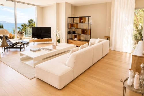 Villa de luxe à Marseille avec vue mer, canapé crème, étagères en bois et accès à la terrasse