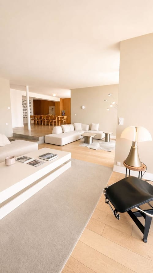 Salon moderne de la Villa JFK à Marseille avec canapé crème, salle à manger en bois et mobilier contemporain