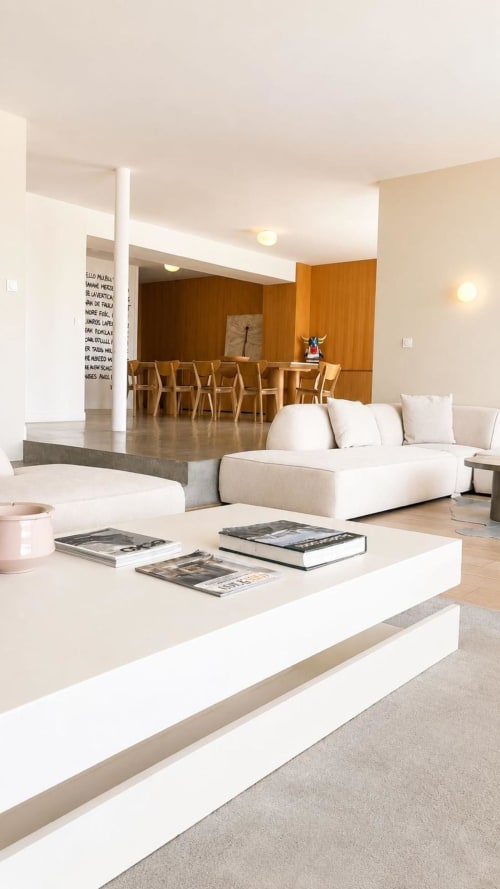 Salon contemporain de la Villa JFK à Marseille avec canapé crème, chaises de salle à manger en bois et table basse blanche
