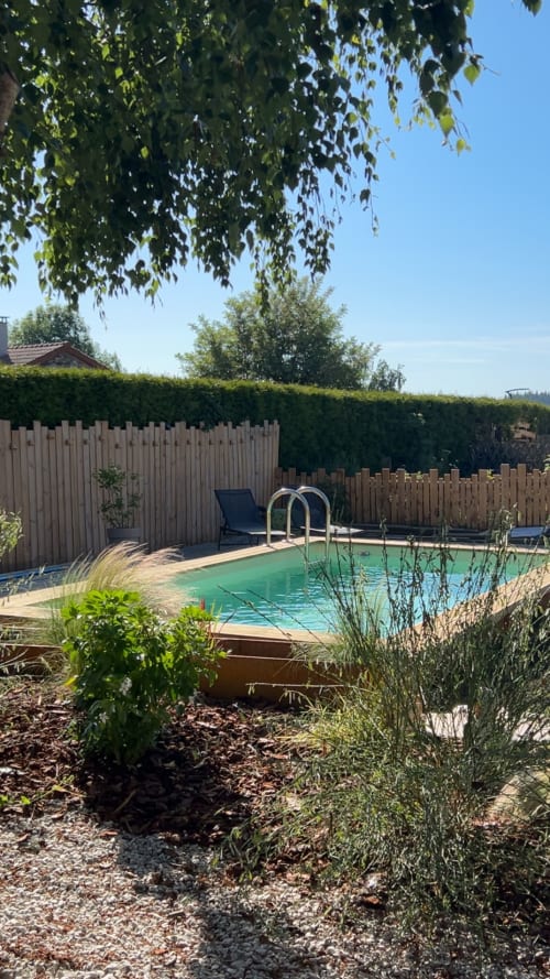 Piscine turquoise avec échelle dans le jardin ensoleillé de l'écolodge Papillons des Sucs à Saint-Maurice-de-Lignon