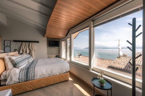Camera di lusso a Casa Giulietta a Sirmione con vista sul lago Como, soffitto in legno e paesaggio di coppi in terracotta