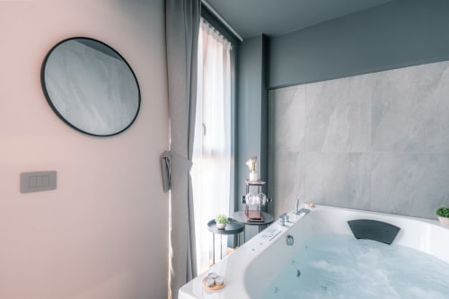 Vasca idromassaggio lussuosa con getti massaggianti all'hotel Casa Giulietta a Sirmione, Como, con arredamento rosa e grigio moderno
