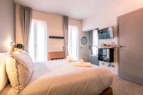 Camera d'hotel moderna a Casa Giulietta a Como con letti gemelli, vista sul lago, TV e arredi contemporanei
