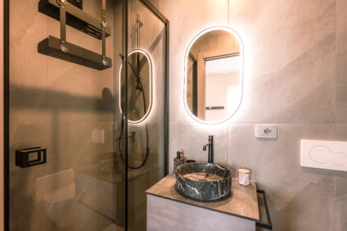 Bagno moderno a Casa Giulietta Como con lavabo a semisfera, specchi LED e cabina doccia in vetro