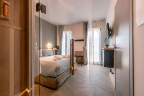 Camera boutique presso Casa Giulietta a Como con specchio, letto queen, divisorio in vetro, vista sul lago e arredamento moderno